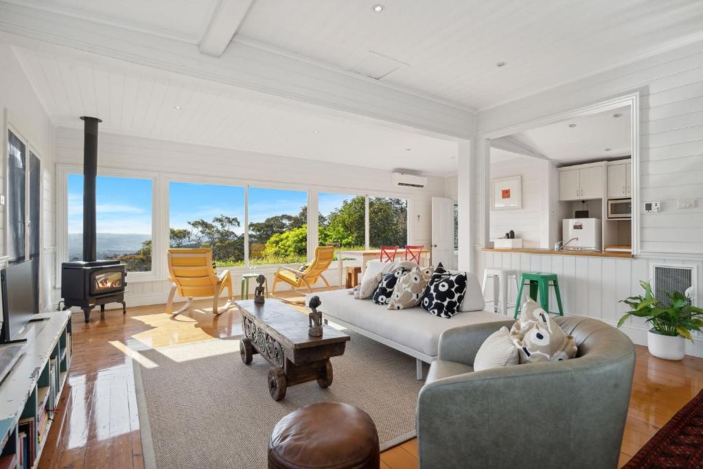 a living room with two couches and a table at Cooee Cottage Spectacular Views Blackheath in Blackheath