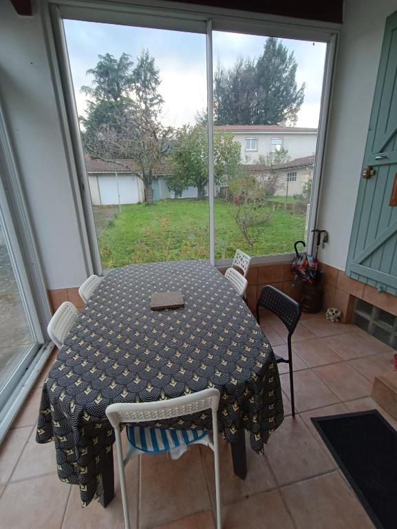 une table et des chaises dans une pièce avec une fenêtre dans l'établissement Maison Aussillon tarn, à Aussillon