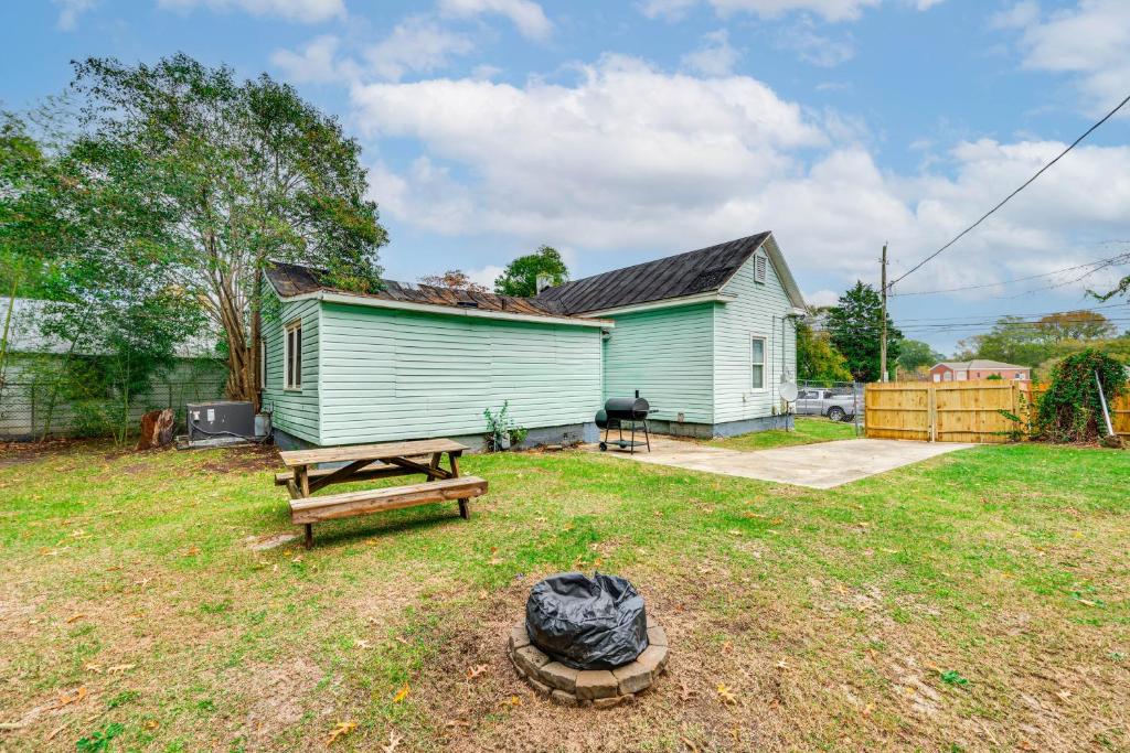 einen Hof mit einer Bank und einem Haus in der Unterkunft 1 Mi to Stadium Home with Porch in Greenville! in Greenville