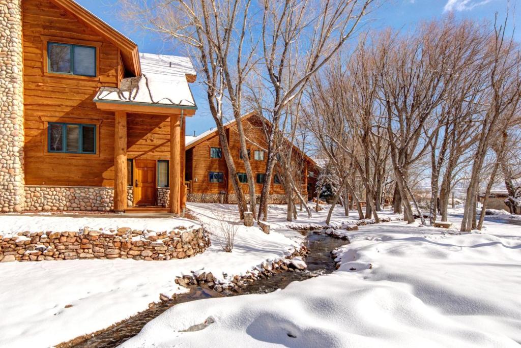 a log home in the snow with a creek at KBM Resorts Timber Wolf Lodge Walk to Canyons Cabriolet Fireplace BBQ Aspens Creek Parking TWL-12c in Park City