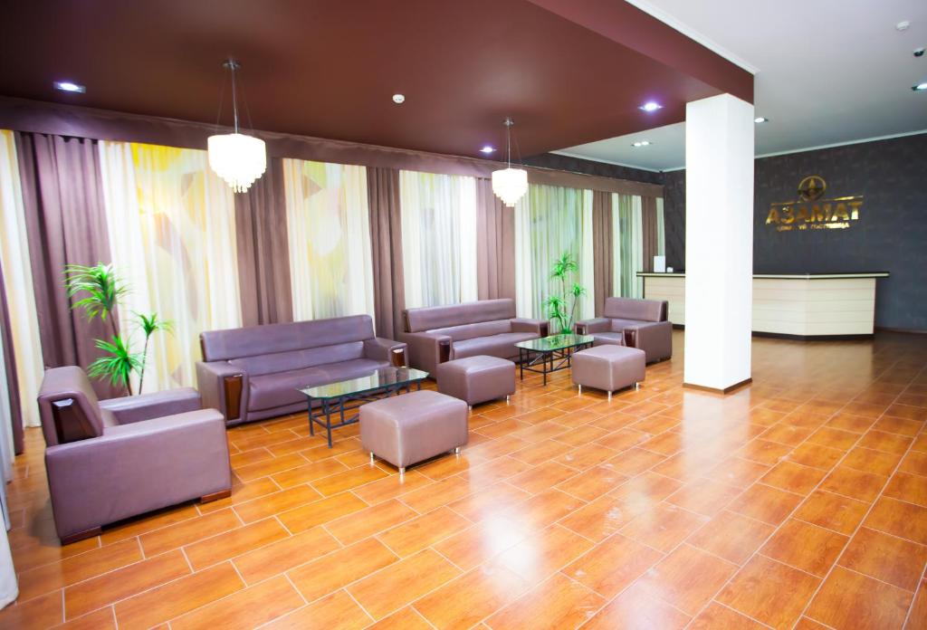 un vestíbulo con sofás, sillas y una mesa en Azamat Hotel en Astaná