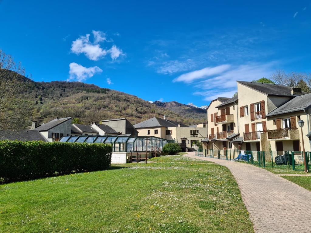 a row of houses with mountains in the background at Escapade Montagne en Famille, appartement cosy avec piscine couverte in Bielle