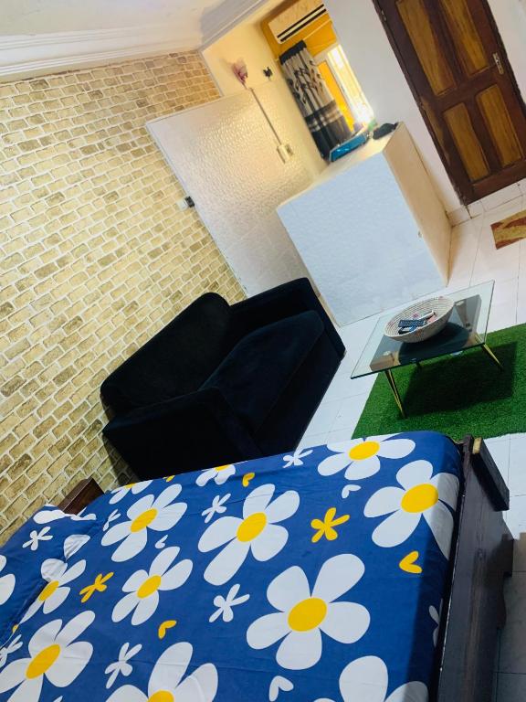 a bedroom with a bed and a couch and a table at Jolie mini studio américain in Dakar