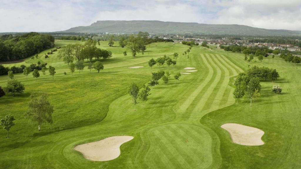 an overhead view of a golf course with two eighteenth greens at The Hedges Hotel in Stranocum