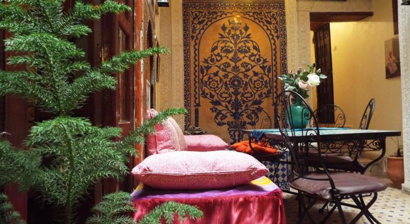 una habitación con mesa y sillas y una habitación con mesa y silla en Dar Fès Huda, en Fez