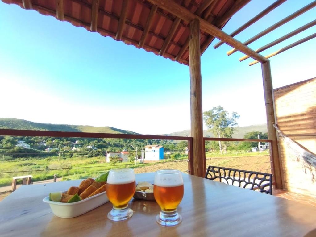 a table with two glasses of beer and a bowl of bread at Chalé Jenipapo in Serra do Cipo