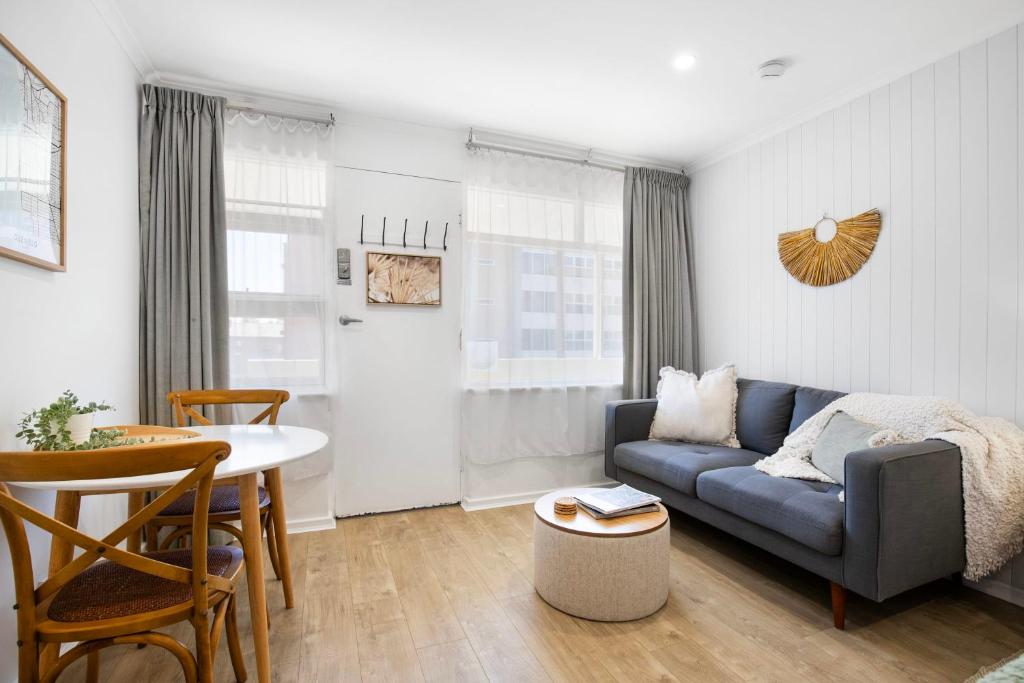 a living room with a couch and a table at Bayscape Studio Glenelg in Glenelg
