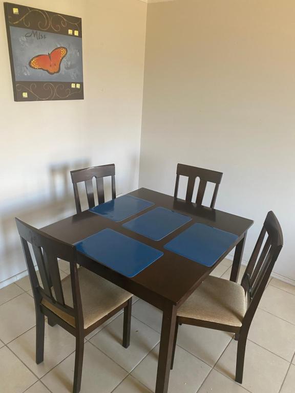 Una mesa de comedor con dos sillas y una mesa azul. en paseo San Carlos, en Coquimbo