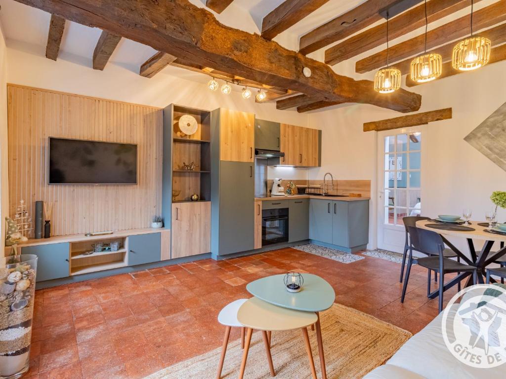 an open kitchen and living room with a table and chairs at Charmant gîte près d'Angers avec extérieur privé - FR-1-622-93 in Andard