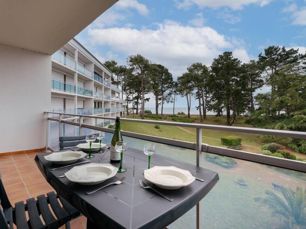a table on a balcony with a view of the ocean at Saint-Philibert: Appart 2 pièces, 53m², terrasse, parking, 4 pers - FR-1-477-249 in Saint-Philibert