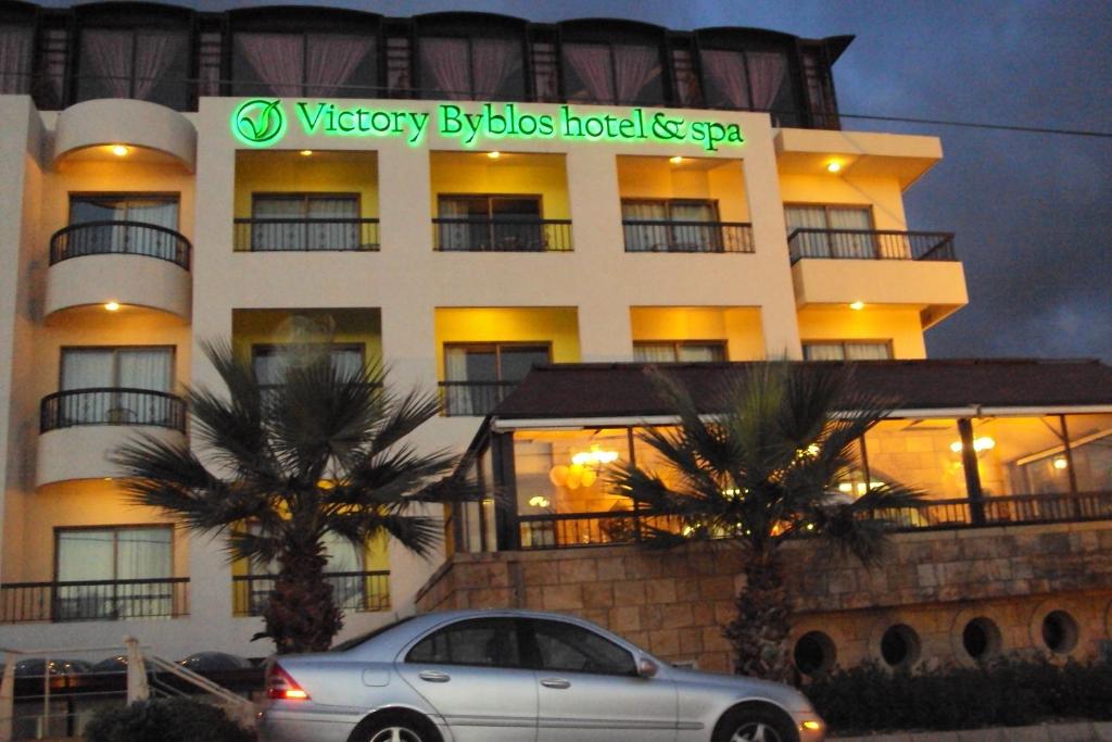una macchina argentata parcheggiata di fronte a un hotel di Victory Byblos Hotel & Spa a Jbeil