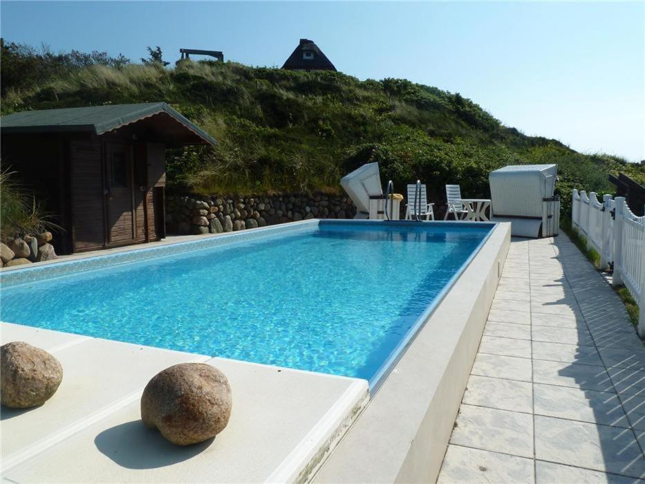 una piscina con rocas en el lateral. en Haus-Excelsior-Wohnung-08, en Rantum