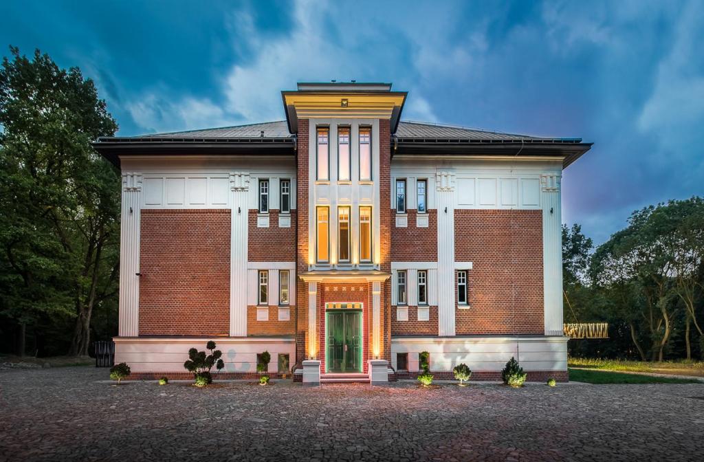 un grand bâtiment en briques avec une porte verte dans l'établissement Vila Na Landeku, à Ostrava