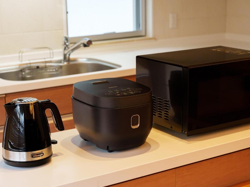 a coffee maker on a counter next to a microwave at Aqua Palace Chatan by Coldio Premium in Chatan
