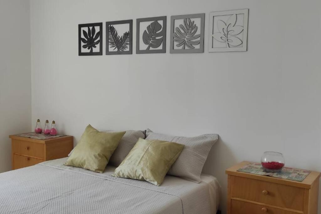 een slaapkamer met een bed met vier foto's aan de muur bij SILVESTRE - Departamento in Cordoba