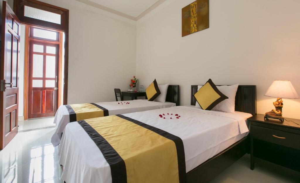 a bedroom with two beds and a window at Snow Pearl Homestay Hoi An in Hoi An