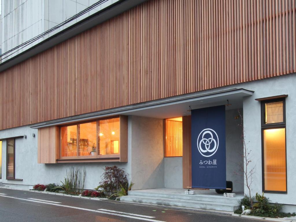 een gebouw met een blauw bord erop bij Hostel Mitsuwaya Osaka in Osaka