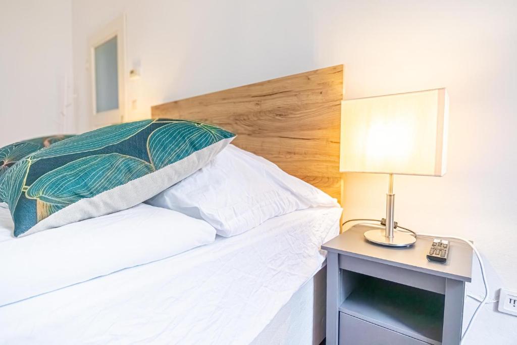 a bedroom with a bed with a lamp on a table at Convenient 3-BR Shared Apt, 15 Min to Landstraße Hub in Vienna