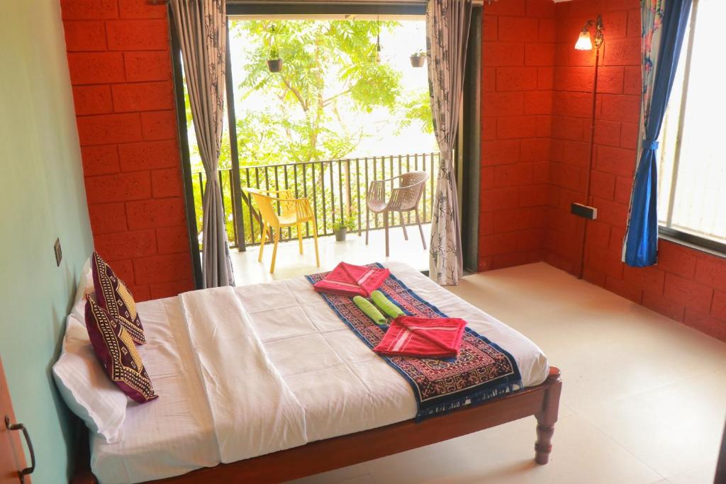 a bedroom with a bed with two presents on it at Orchid View Villa Mahabaleshwar 2 Bhk Villa in Mahabaleshwar