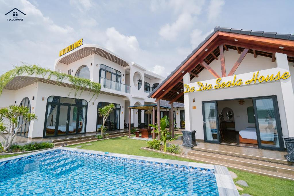 a villa with a swimming pool in front of a building at Da Dia Seala House in Phú Hạnh (5)