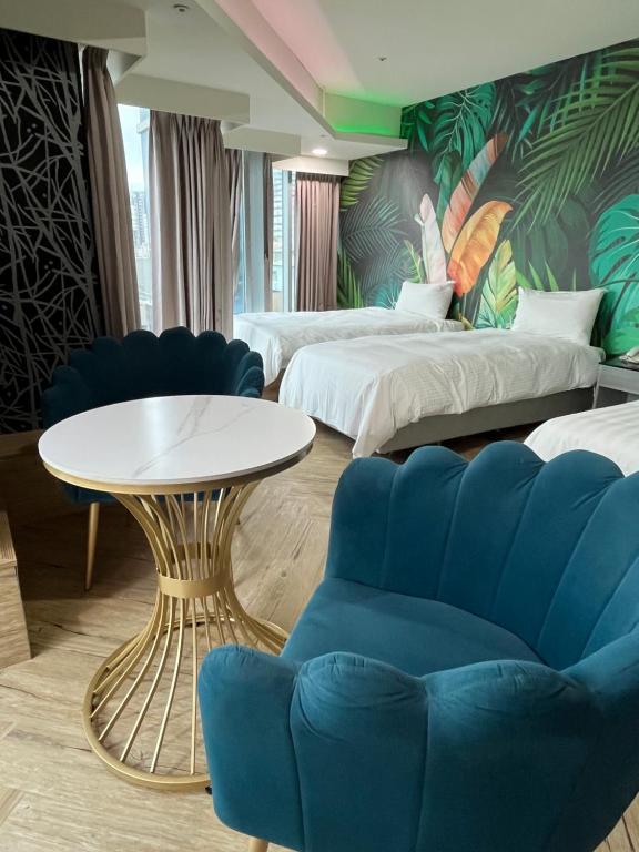 a hotel room with two beds and a table and a couch at 以琳文旅 in Zhongli