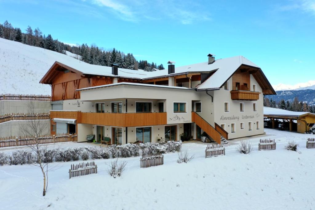 a large building in the snow with snow covered at ALMRESIDENZ UNTERRAIN -1 km BY CAR DISTANCE SKI SLOPES KRONPLATZ in Valdaora