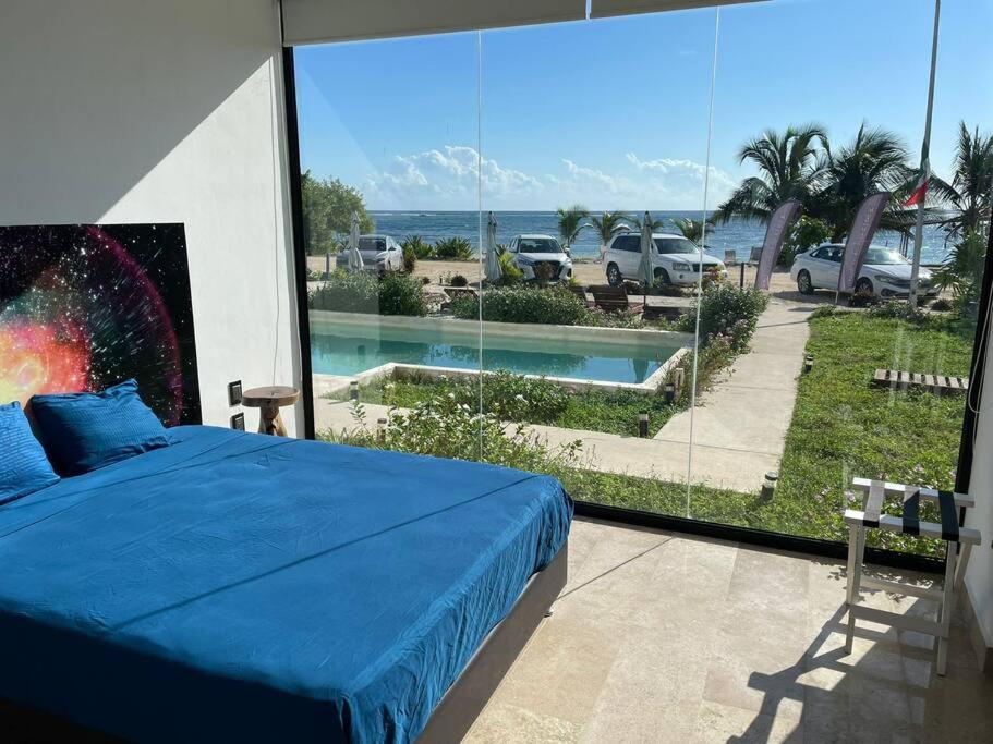 a bedroom with a bed and a view of a pool at Mahaguay - Bello dto frente al mar in Mahahual