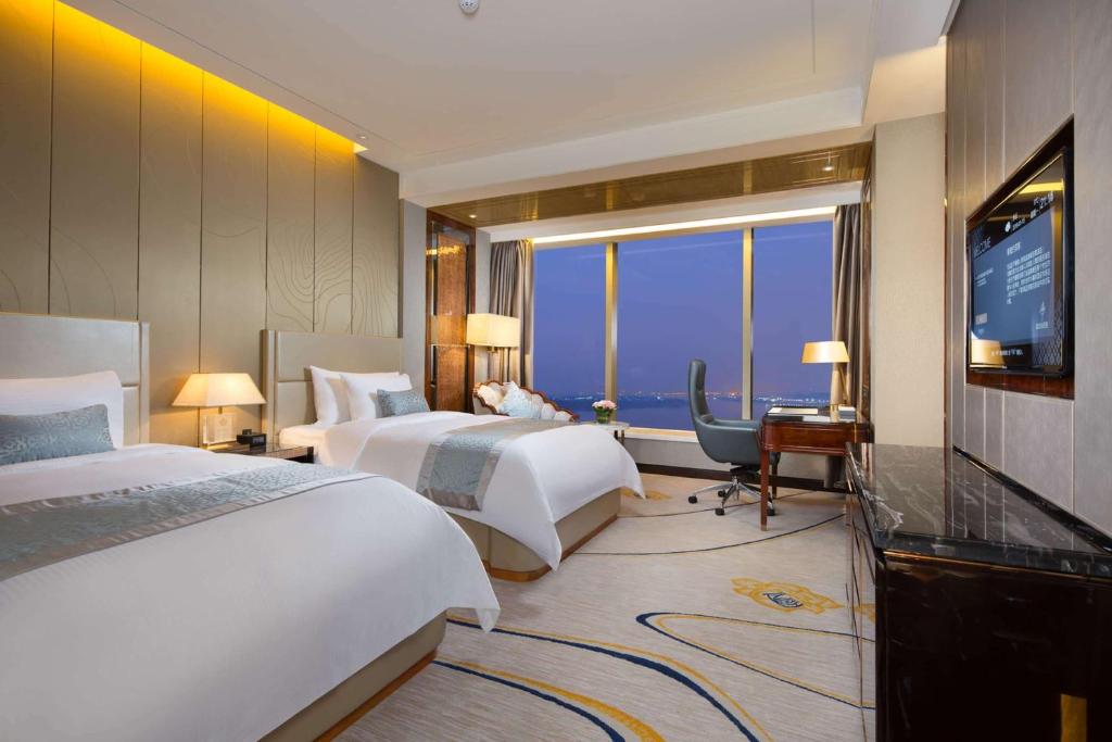 Postel nebo postele na pokoji v ubytování Wyndham Grand Foshan Gaoming