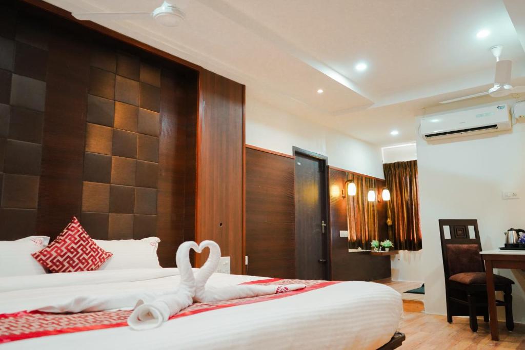a hotel room with a bed with a heart decoration on it at Hotel RD in Perundurai