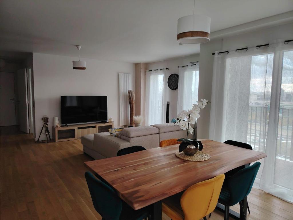 un salon avec une table et un canapé dans l'établissement Grand appartement familial paris13, à Paris