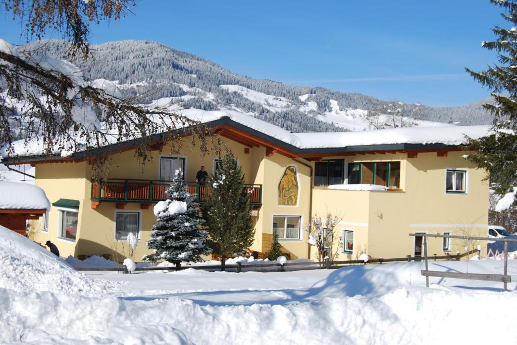 ein schneebedecktes Haus davor in der Unterkunft Ferienhaus Emberger in Wagrain