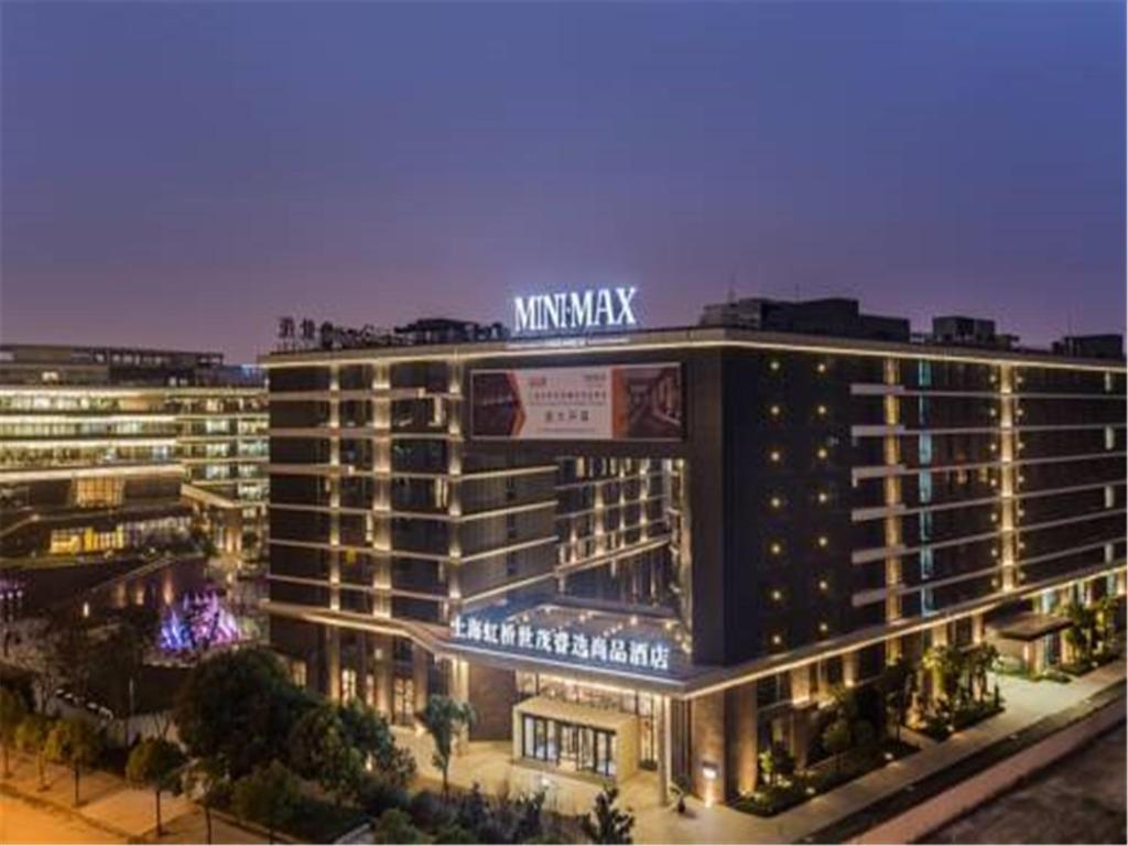 a large building with a sign on top of it at MiniMax Premier Hotel Shanghai Hongqiao in Shanghai