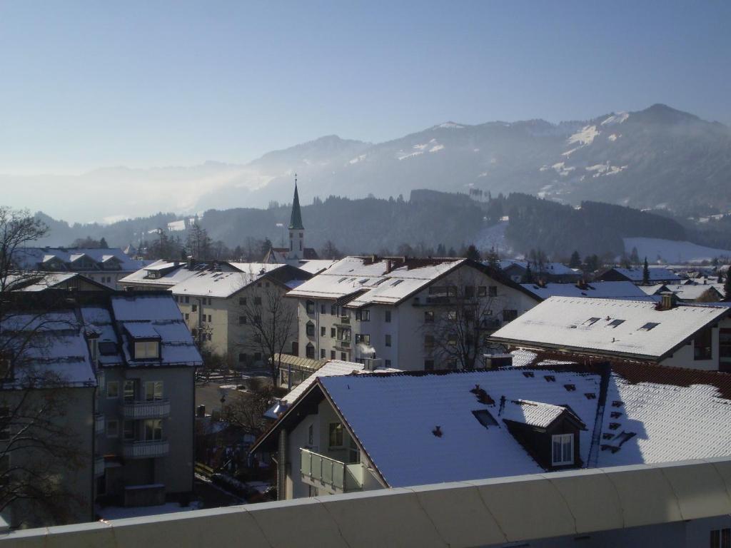 una città con tetti ricoperti di neve e una chiesa di PenthouseApartment 250° a Sonthofen