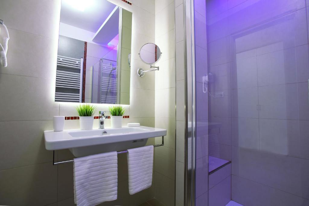 a white bathroom with a sink and a shower at Hotel Cicò in Torre Santa Sabina