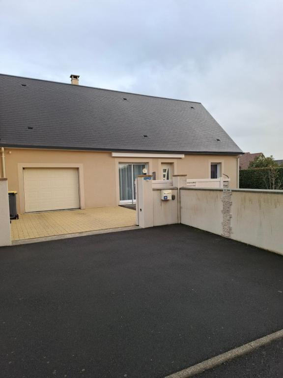 a house with a parking lot in front of it at Le petit coin de Paradis classé 3 étoiles in Hermanville-sur-Mer