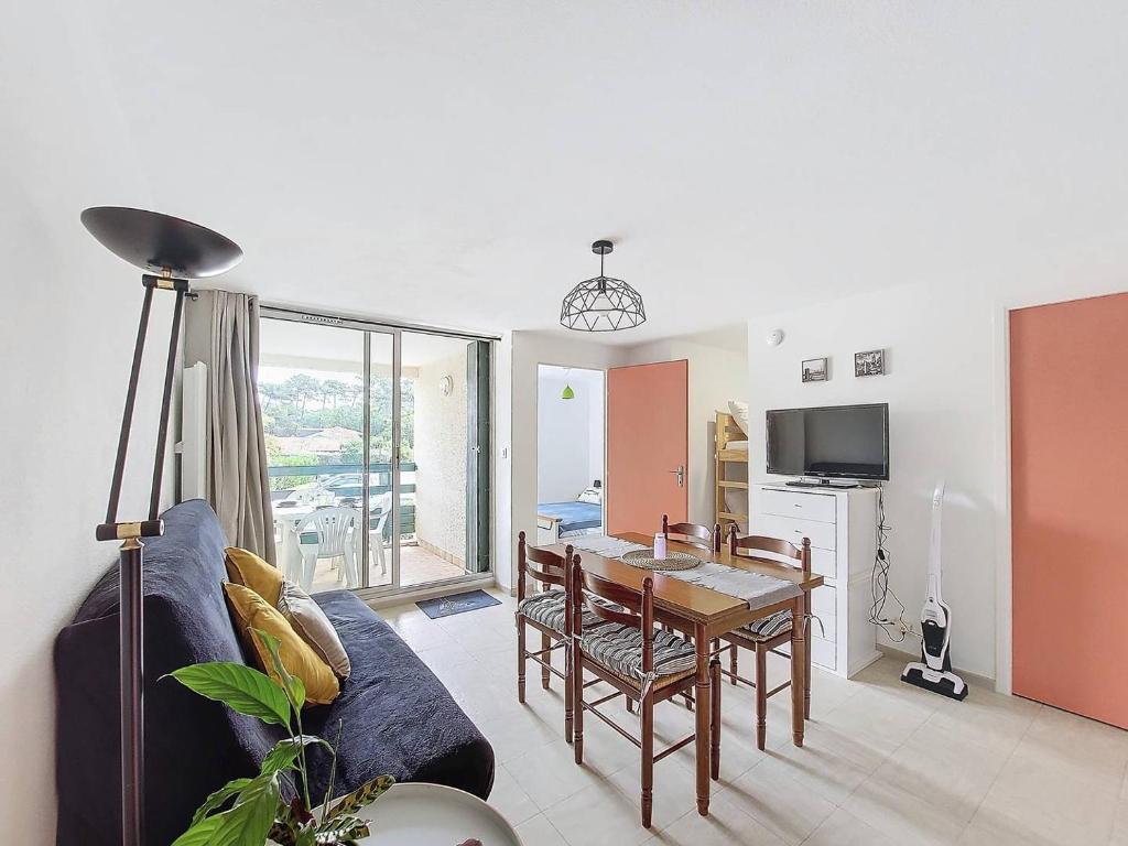 un salon avec une table et une salle à manger dans l'établissement S-Lac 03-Soutons Appartement 4 personnes dans résidence au bord du lac marin, à Soustons