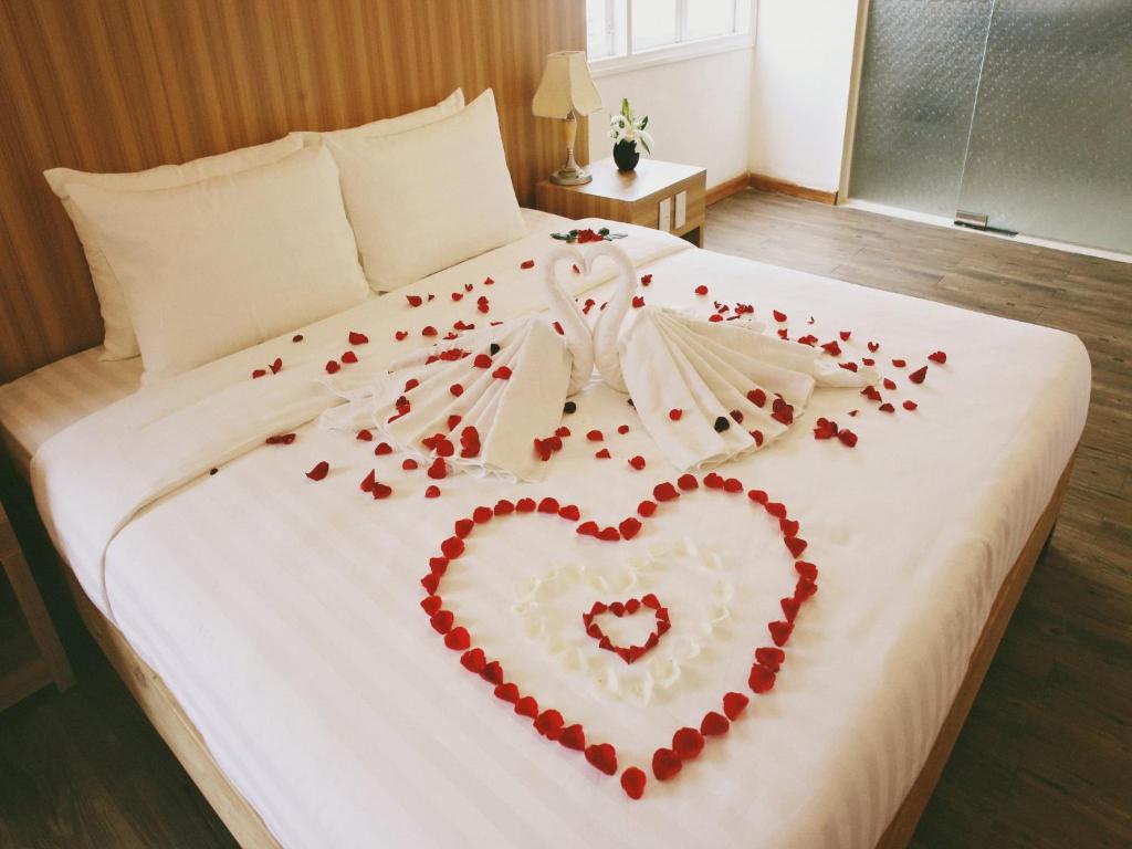 Una cama con un corazón hecho de pedales rojos en Jasmine Hotel, en Hue