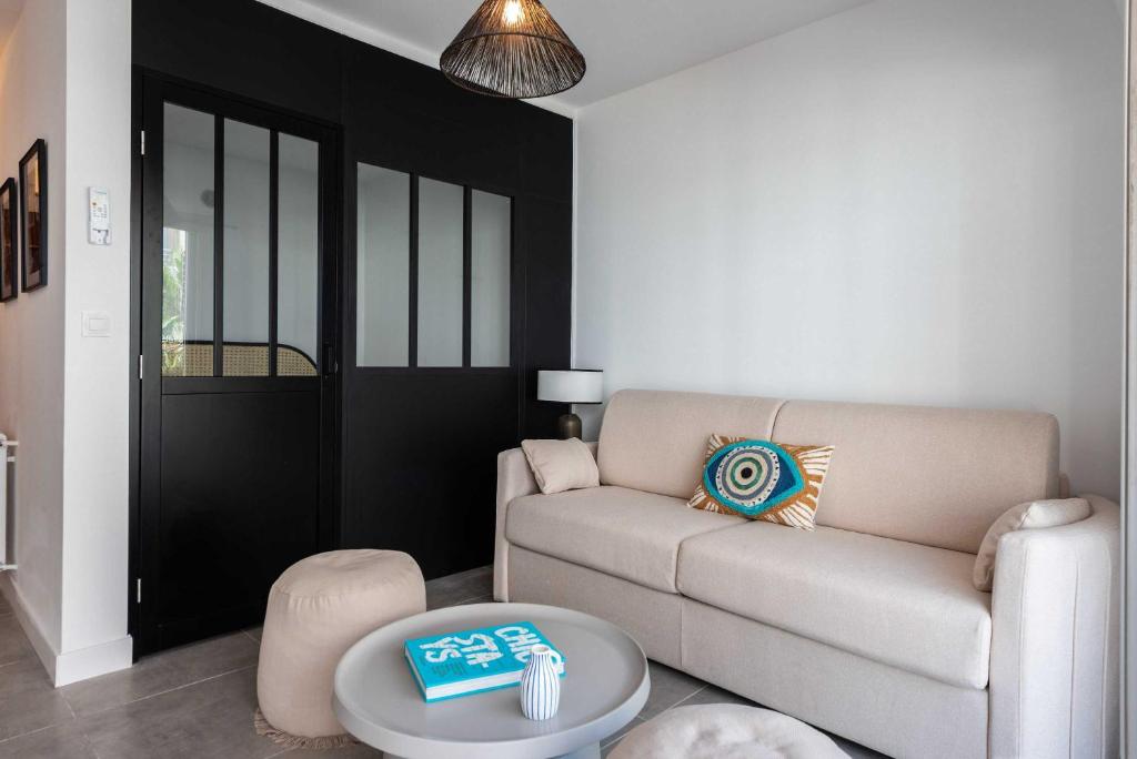 un salon avec un canapé et une table dans l'établissement Beautiful flat with balcony - 200m from the beach, à Antibes