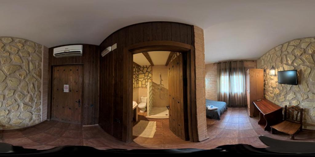 una habitación de hotel con un espejo grande y un dormitorio en Posada de los Cónsules, en Consuegra