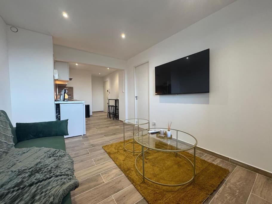 un salon avec une table en verre et un canapé dans l'établissement Le Castillet chic, à Perpignan