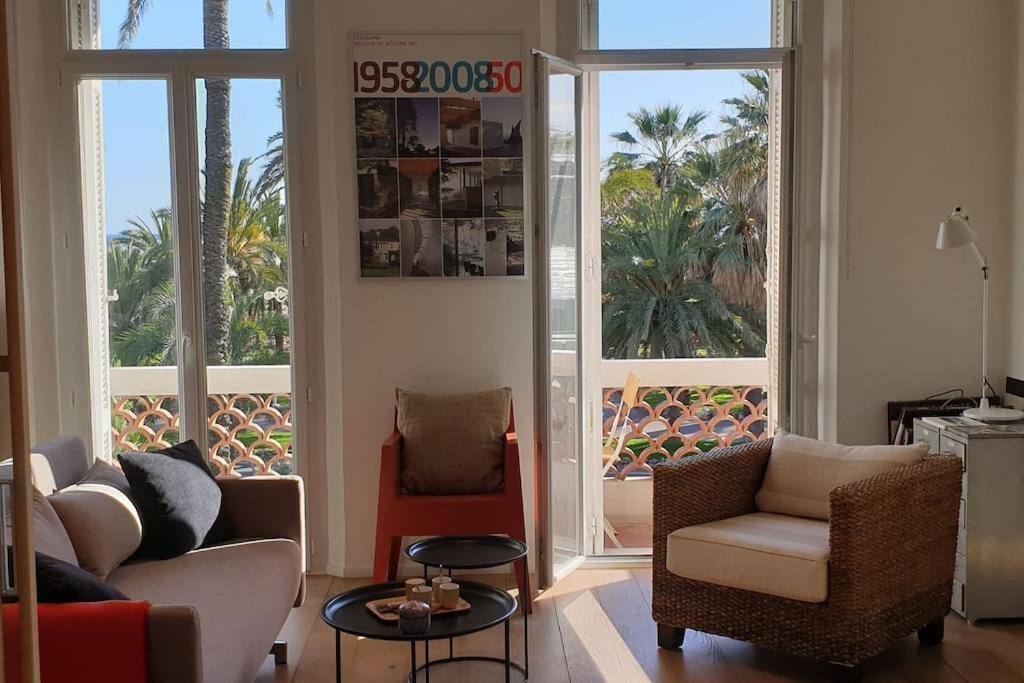 un salon avec un canapé, des chaises et des fenêtres dans l'établissement Cannes Croisette Loft, à Cannes