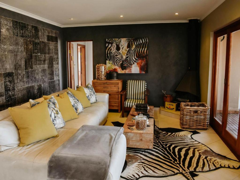 a living room with a couch and a zebra rug at Cwebile Guesthouse in Winterton