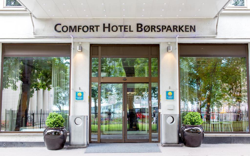 a hotel entrance with two potted plants in front of it at Comfort Hotel Børsparken in Oslo