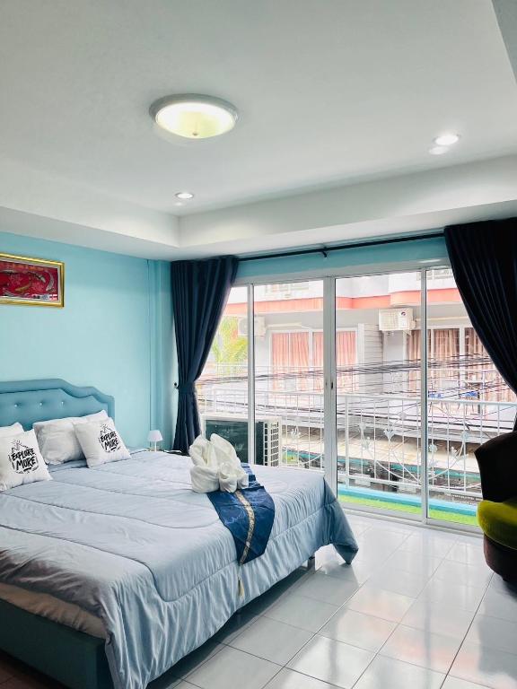 a bedroom with a bed and a large window at Ocean Blue Huahin Guesthouse in Hua Hin