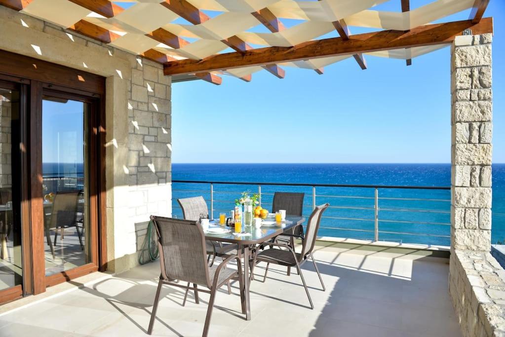 un patio con tavolo e sedie e l'oceano di Petrina Villa A a Kastrí