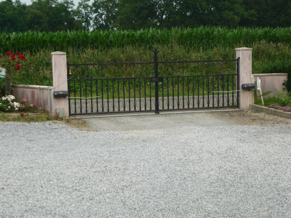 an iron gate in front of a field of flowers at Maison familiale avec jardin à Lahosse, 110 m² in Lahosse