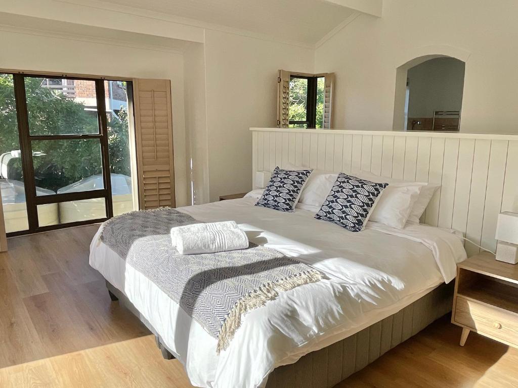 Un dormitorio con una cama grande con almohadas. en Ocean Mooring Beach Apartment " no sea view, 50m from beach", en Port Alfred