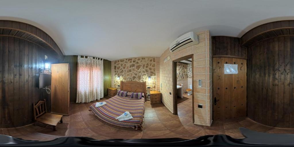 sala de estar con sofá en una habitación con paredes de madera en Posada de los Cónsules, en Consuegra