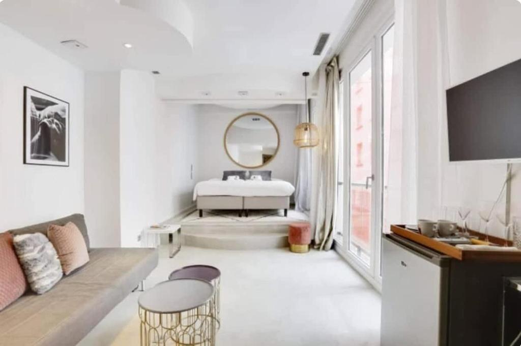 une salle de bain blanche avec une baignoire et un miroir dans l'établissement Magnifique appartement parisien - Marais, à Paris