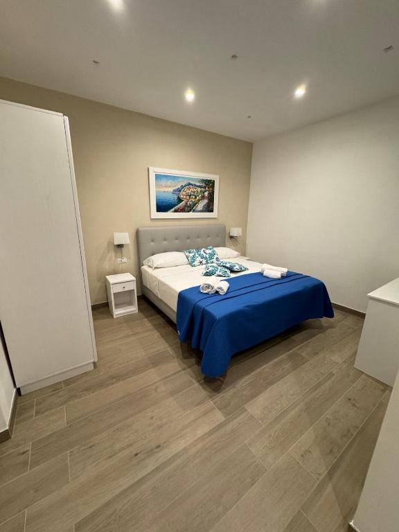 a bedroom with a large bed with a blue blanket at Sorrento Bay Apartment in Sorrento